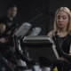 Girl in Black Sport Clothes Works Out on a Bike at Gym - VideoHive Item for Sale