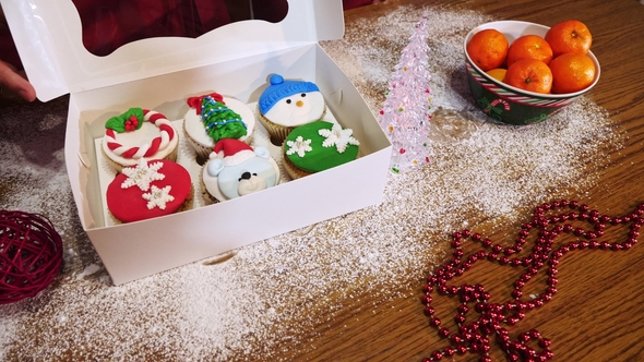 Woman´s Hands Closes Box with Amazing Christmas Cupcakes