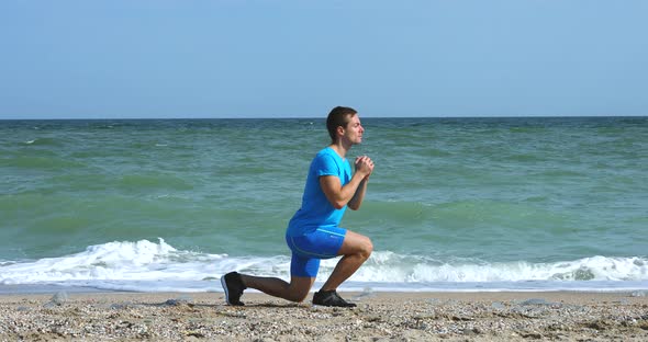 Young Man Doing Lunges Exercise at Ocean Beach