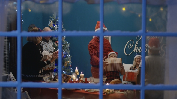 Excited Family Exchanging with Presents at Christmas