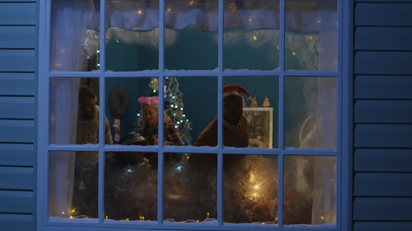 Excited Friends Looking Out in Window During Christmas