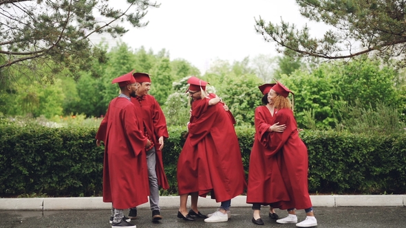 Multiethnic Group of Friends Graduates Are Hugging, Doing High-five and Dancing in Mortar-boards and