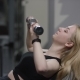 Pretty Blonde Girl with Straight Hair in a Black Sport Wear with Blue Eyes Does a Dumbbell Press on - VideoHive Item for Sale