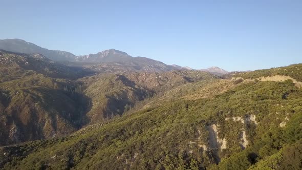 Flying over green mountain pass road