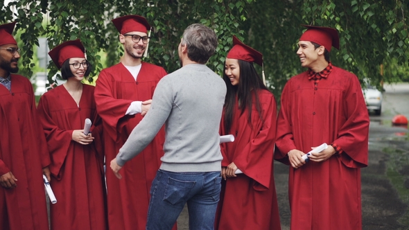 of Proud University Teacher Hugging His Students and Shaking Hands, Graduating Students Are