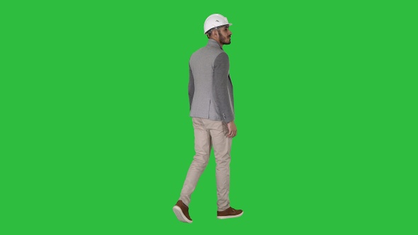 Walking engineer in helmet on a Green Screen, Chroma Key