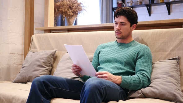 Upset Man Disappointed While Reading Documents, Paperwork