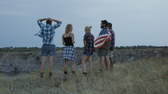 Traveling Friends with Flag on Cliff