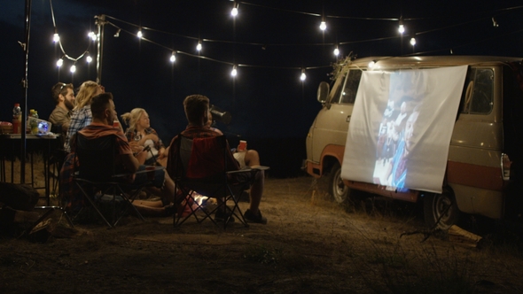 Friends Watching Movie in Campsite