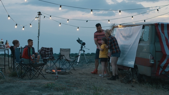 People with Children Playing Charades in Campsite