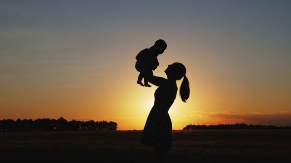 Silhouette of Mother with Child at Sunset