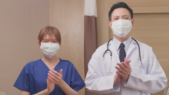 Portrait of Asian doctor and nurse giving encourage to patient by clapping the hands with smile.