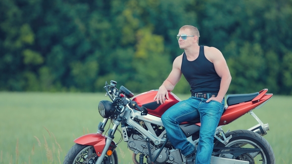 Side View of Beautiful Motorcyclist Sitting on Standing on the Side of the Motorcycle Seat 