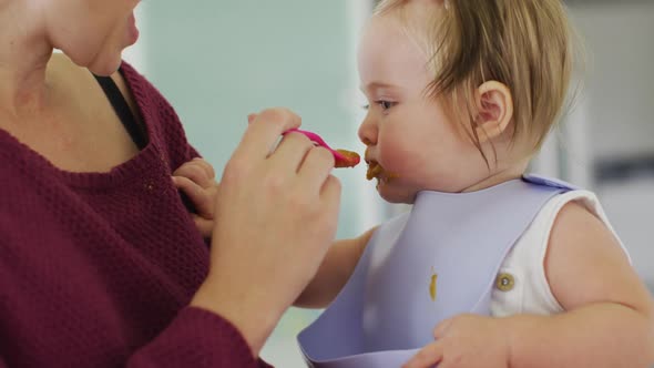 Close up of caucasian mother feeding her baby at home