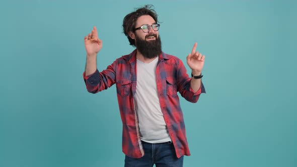 Young Bearded Man Dancing and Posing Over Turquoise Background