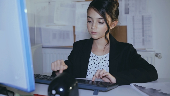 Stylish Young Girl Willingly Works with Computer in Office