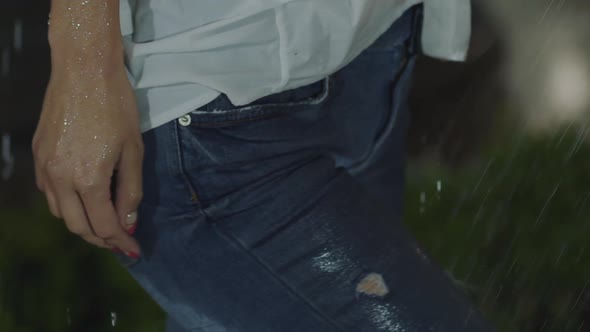 Unrecognizable Woman Gets Wet in the Night Rain and Poses