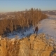 A Man Stands on the Edge of a Cliff and Enjoys the Sunset - VideoHive Item for Sale