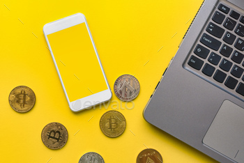phone with blank mock up screen, crypto currency coins and laptop computer
