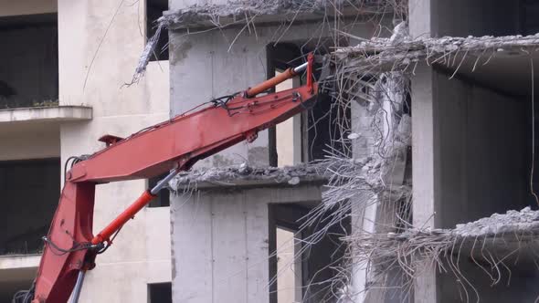 Destroying Old Concrete House Using Mechanical Arm of Bulldozer on Construction Site