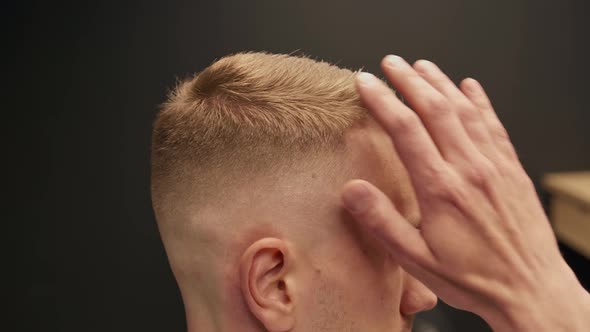 Barbershop: man looking at his haircut after cutting hair and beard