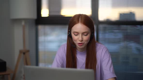 Closeup Face of Friendly Young Woman Operator Using Headset and Laptop Computer During Customer