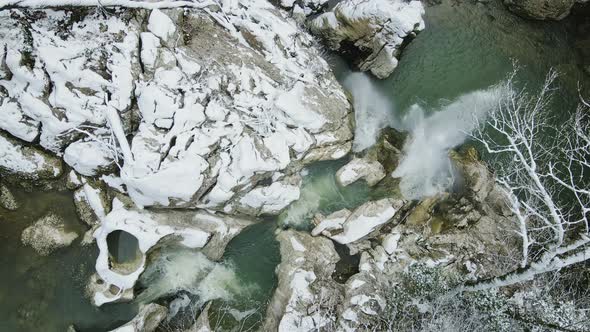 Waterfall Flowing From White Rocks Into a Lake in the Forest