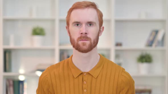 Portrait of Serious Redhead Man Looking at Camera