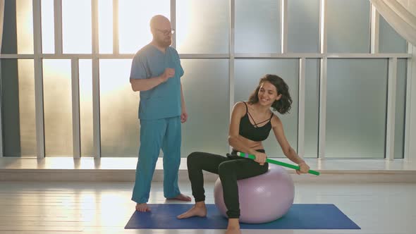 A Physical Therapist Safely Trains a Patient Using Medical Exercise Equipment