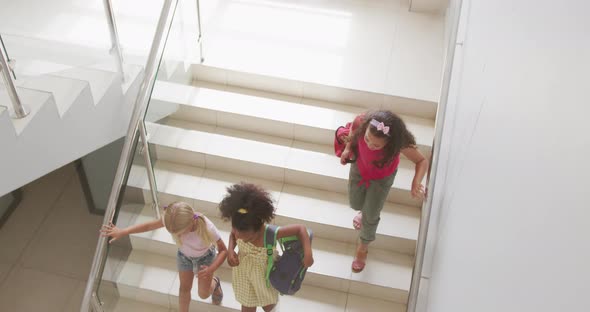 Video of top view of diverse girls walking downstairs at school