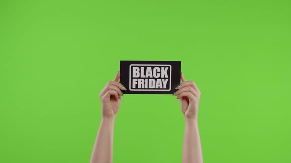 Black Friday Advertisement Inscription on Paper Sheet in Womans Hands on Chroma Key. Slow Motion