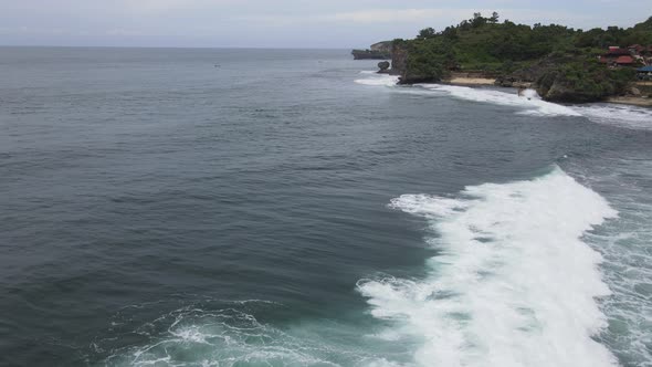 Flying Over ocean alongside tropical beach in Indonesia. Bird Eye View 4K Cinematic Drone Footage.