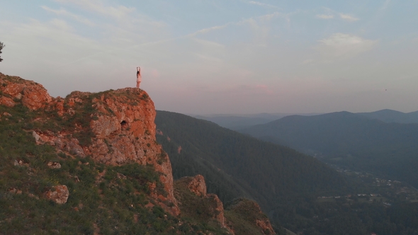 Young Happy Woman Standing on the Edge of a Cliff