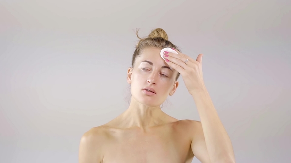 Attractive Woman Is Cleaning Her Skin with Cotton Pads and Cleansing Lotion and Enjoying Her Soft