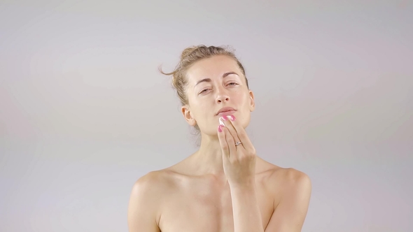 Attractive Woman Is Cleaning Her Skin with Cotton Pads and Cleansing Lotion and Enjoying Her Soft