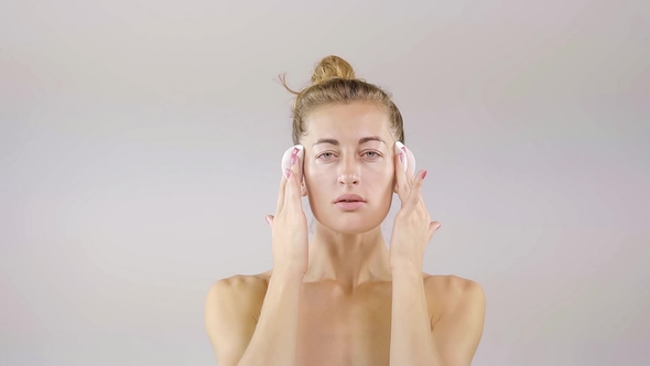 Attractive Woman Is Cleaning Her Skin with Cotton Pads and Cleansing Lotion