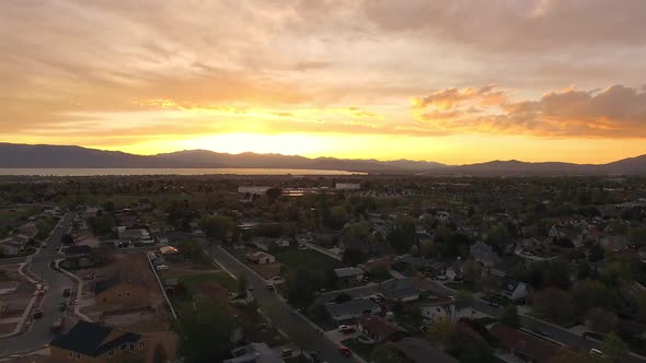 Aerial time lapse over neighborhood during colorful sunset