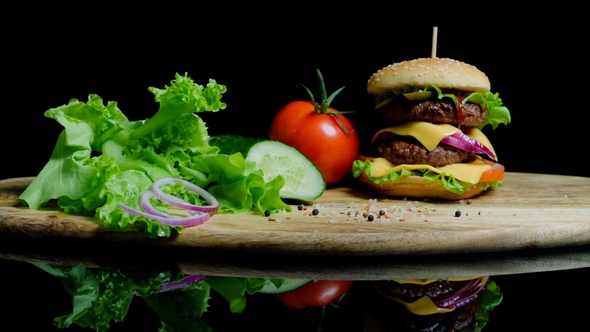Fresh Vegetables and Tasty Burger with Cheese and Beef Cutlets on the Black Background