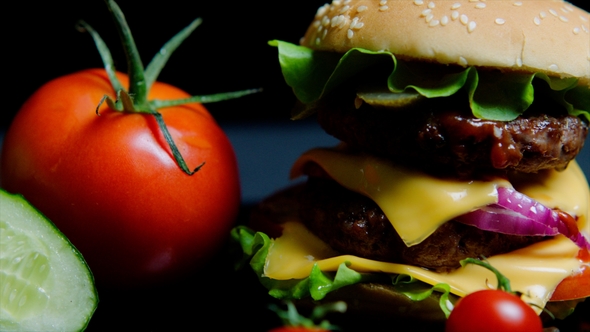 Fresh Vegetables and Tasty Burger with Cheese and Beef Cutlets on the Black Background