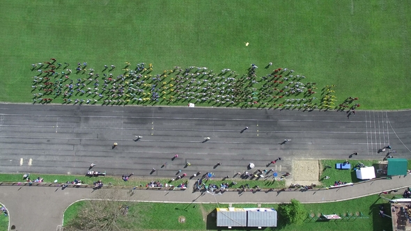 Aerial Shot. Group of People at the Stadium Doing Exercises. Sports Warm-up From a Height. The View