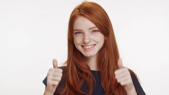 Smiling Beautiful Redhead Caucasian Teenage Girl Showing Ok with Two Thumbs on White Background in
