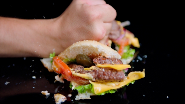 The Fist Smashes Burger Into Pieces. Black Mirror Surface