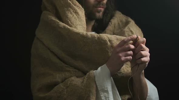 Jesus in Robe Showing Christian Cross, Crucifixion Symbol, Dark Background