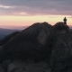 Drone Shot of Lonely Man Standing on Top of a Mountain and Enjoying the Sunset - VideoHive Item for Sale