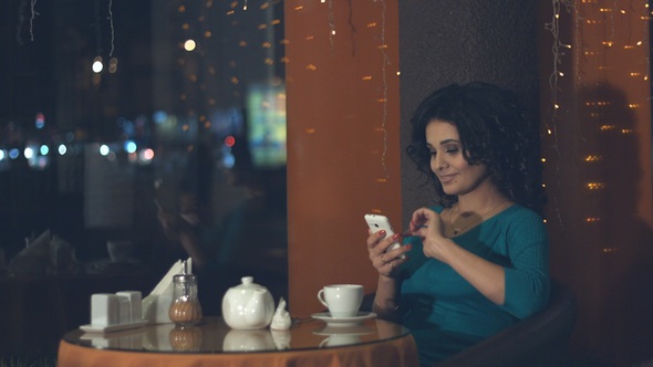 Girl with Smartphone in Cafe