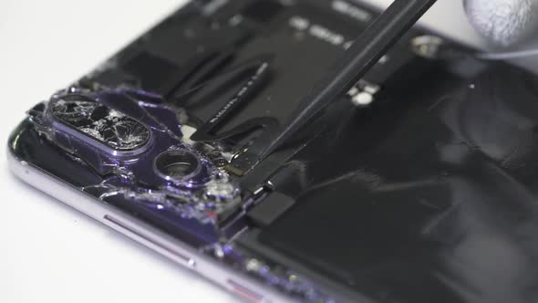  Mobile phone repair service. A technician removing the camera flex