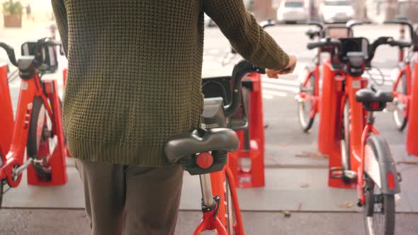 Tourist Man Take Electric Kick Scooter or Bike Bicycle in Sharing Parking Lot Tourist Phone