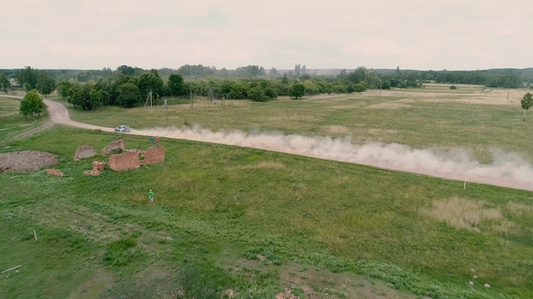 Fly Over Abandoned Farm To Rally Car on Road