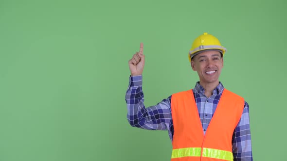 Happy Multi Ethnic Man Construction Worker Talking While Pointing Up