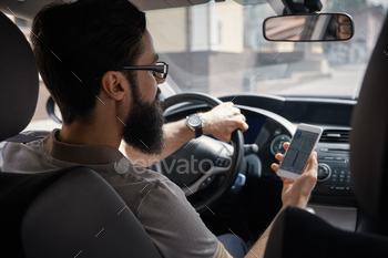 gps or navigator application via mobile smartphone inside a car while driving car – back view. Technology, distraction and driving concept